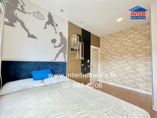 Bedroom with sports-themed wall art, a bed, and brick accent wall