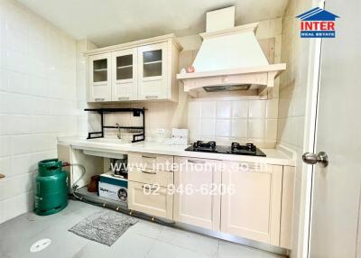 Modern kitchen with gas stove, cabinets, and shelving