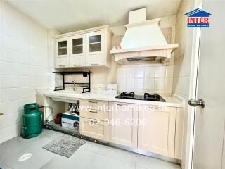 Modern kitchen with gas stove, cabinets, and shelving