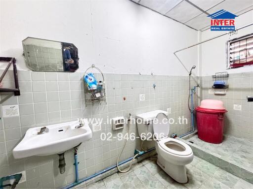 Bathroom with toilet, sink, mirror, and a small window
