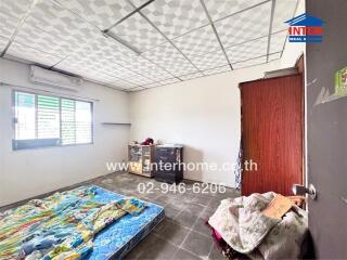 Bedroom with basic furnishings, a mattress, and tiles floor