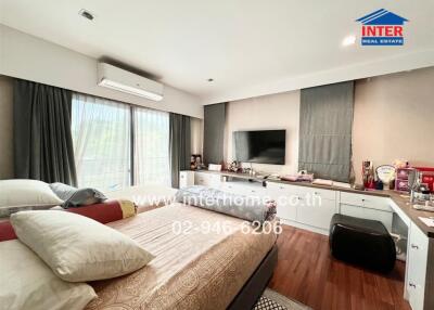 Spacious bedroom with large window, air conditioner, and television