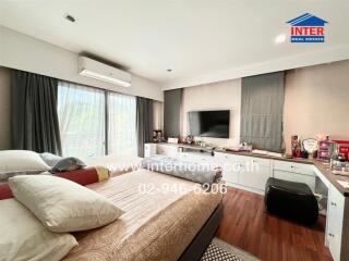 Spacious bedroom with large window, air conditioner, and television