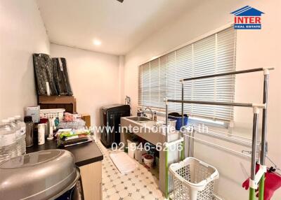 Laundry room with washer, storage space, and cleaning supplies