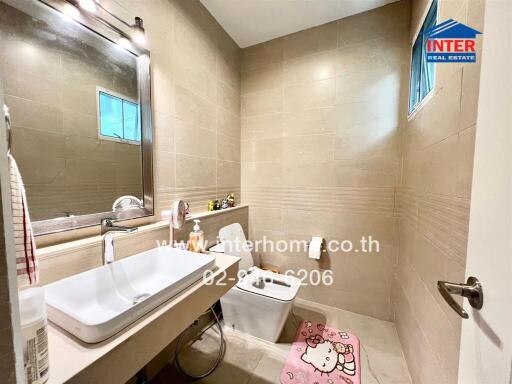 Modern bathroom with sink, toilet, and mirror