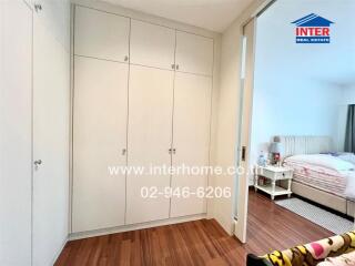 Bedroom with white wardrobe and bed