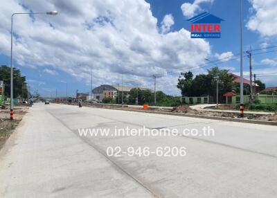 Photo of a road with buildings on both sides under a clear sky