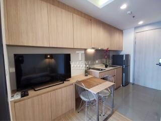 Modern kitchen with TV, dining table, and appliances