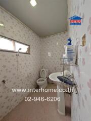 Bathroom with wall tiles, sink, toilet, and shower area