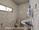 Bathroom with wall tiles, sink, toilet, and shower area