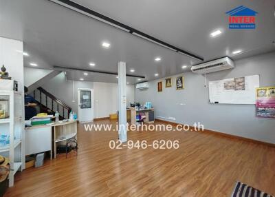 Spacious modern living room with laminate flooring, air conditioning, and ample lighting
