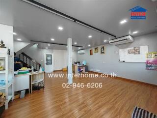 Spacious modern living room with laminate flooring, air conditioning, and ample lighting