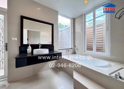 Modern bathroom with a floating black vanity, wall-mounted sink, large mirror, bathtub, and large windows