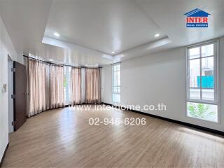 Spacious living room with large windows and wooden floor