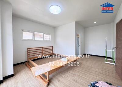 Unfurnished bedroom with bed frame and wooden flooring