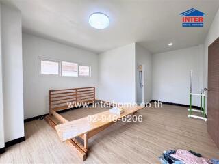 Unfurnished bedroom with bed frame and wooden flooring