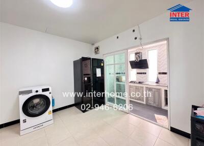 Laundry room with washing machine, doorway to kitchen