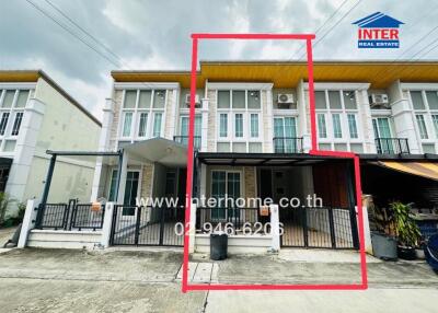 Front view of townhouse with three floors and a gated front area