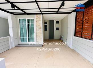 Covered outdoor area with tiled flooring and glass doors