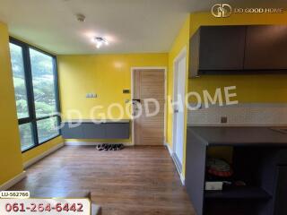 Bright living area with large windows, yellow walls, and wooden flooring