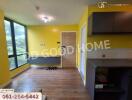 Bright living area with large windows, yellow walls, and wooden flooring