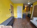 Bright living area with yellow walls and wood flooring