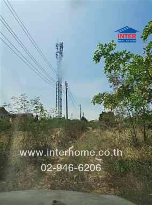 vacant land with cell towers and greenery