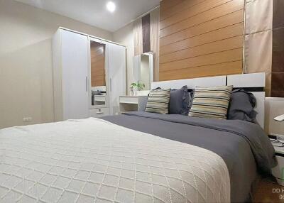 Cozy and modern bedroom with wooden accent wall and white furniture