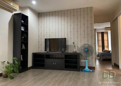 Modern living room with television, fan, and decorative items