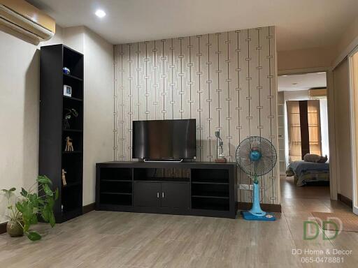 Modern living room with television, fan, and decorative items