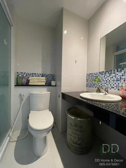 Modern bathroom with a white toilet, glass shower, and sink on a black countertop