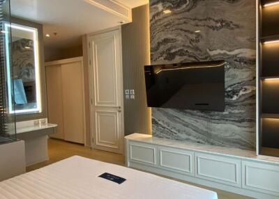 Modern bedroom with a mounted TV and accent wall