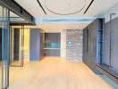 Modern living area with glass sliding doors, wooden flooring, brick accent wall, and built-in shelving