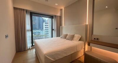 A modern bedroom with a large bed, floor-to-ceiling window with curtains, and a built-in mirror wardrobe.