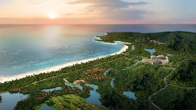 Aerial view of a coastal area with resorts, beach, and lush greenery