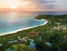 Aerial view of a coastal area with resorts, beach, and lush greenery