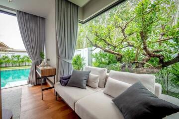 Contemporary living room with large windows overlooking a garden and pool