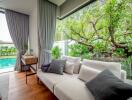 Contemporary living room with large windows overlooking a garden and pool