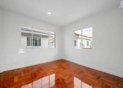 Empty bedroom with large windows and wooden floors