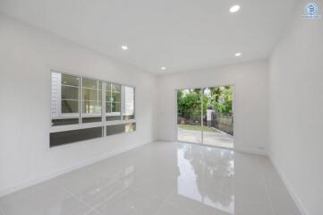 Modern living room with large windows and sliding glass doors leading to a backyard