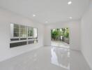 Modern living room with large windows and sliding glass doors leading to a backyard