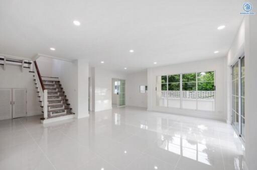 Spacious main living area with large windows and stairs