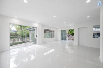 Spacious and bright living area with large windows and tiled flooring