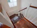 Interior staircase with wooden steps and white railing