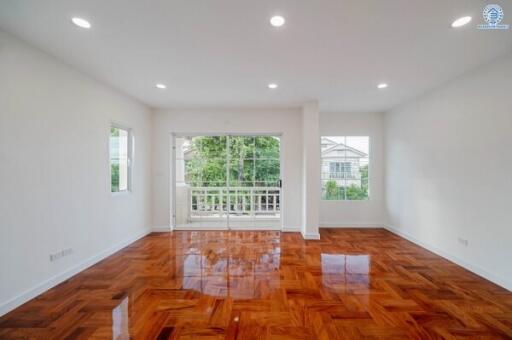 Spacious living room with hardwood floors and large windows