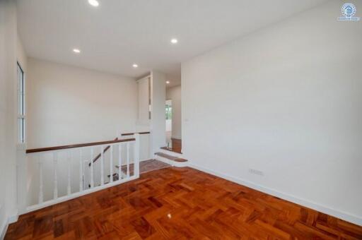 Spacious living room with hardwood flooring and bright lighting