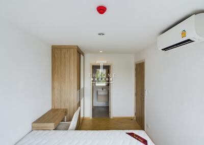 Bedroom with adjoining bathroom, air conditioning, and wooden furniture