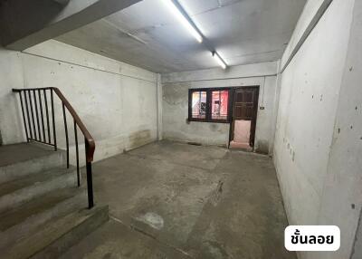 Empty basement with concrete floor and staircase