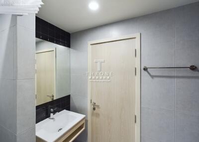 Modern bathroom with sink, mirror, and wooden door