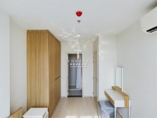 A modern bedroom with wooden closet and minimalistic furnishings